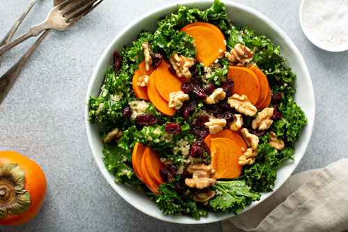 kale salad with fuyu persimmons, walnuts and cranberries