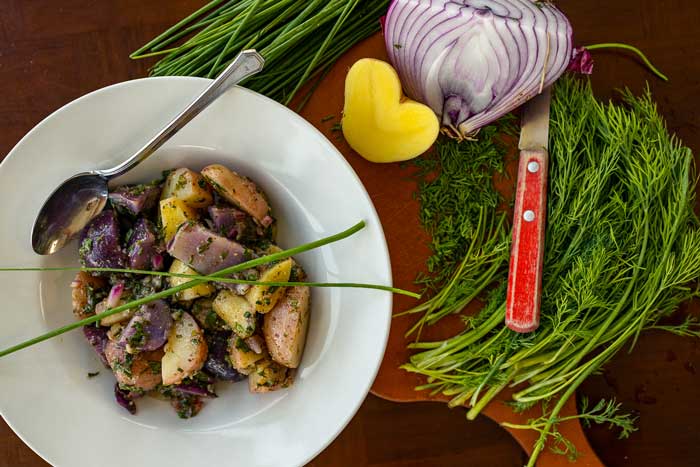 red white and blue new potato salad in a bowl