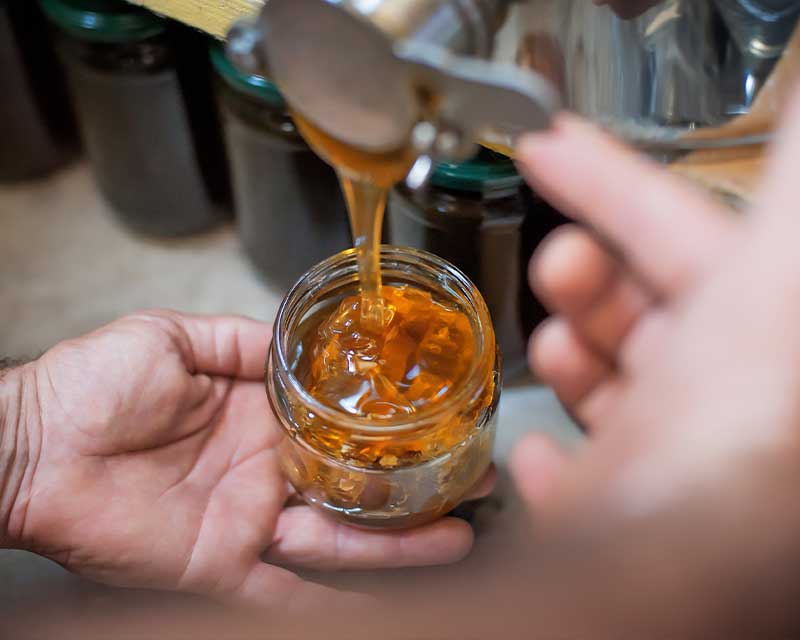 Honey being poured into a jar