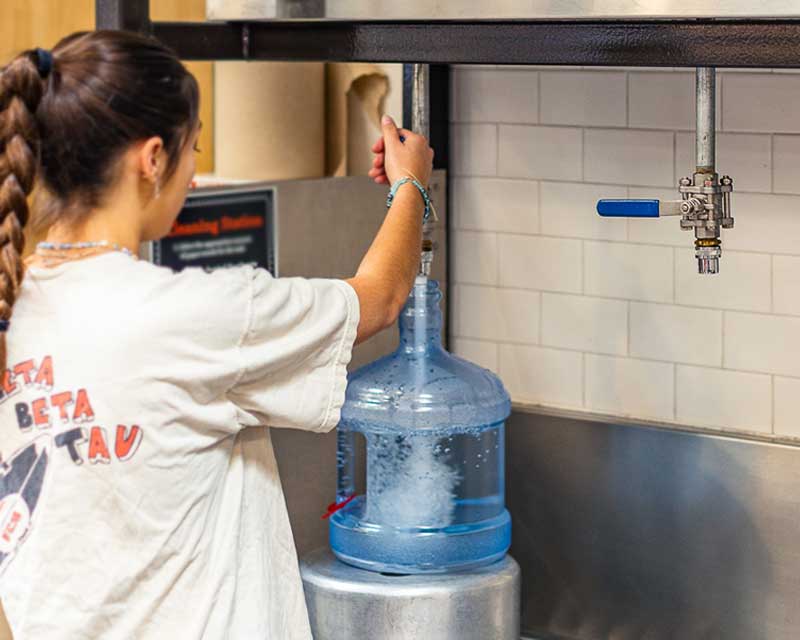 A person filling a container with water