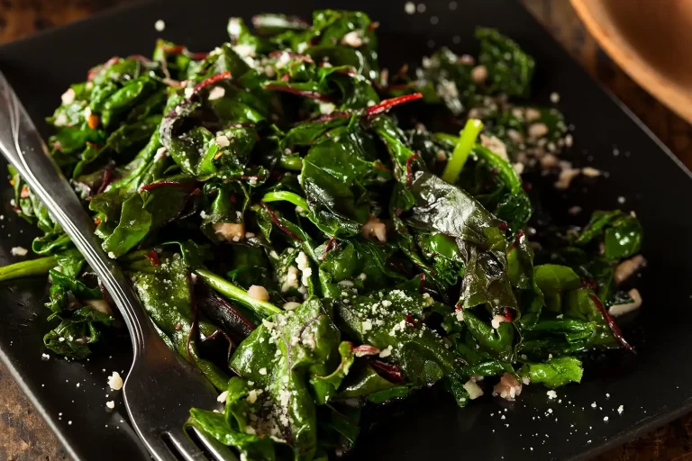 sauteed greens with garlic on a black plate