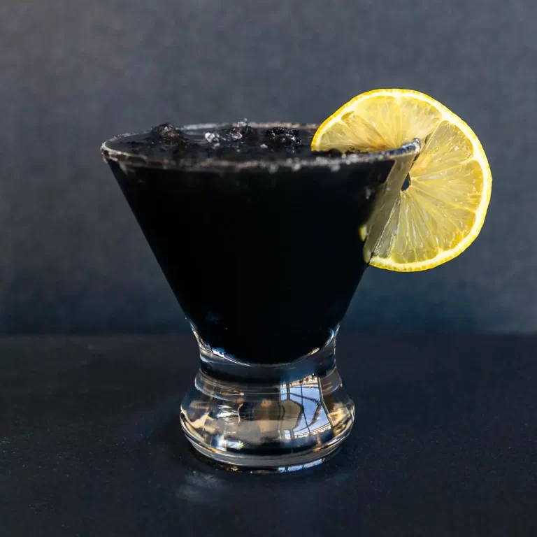 Charcoal lemonade in a glass with a slice of lemon