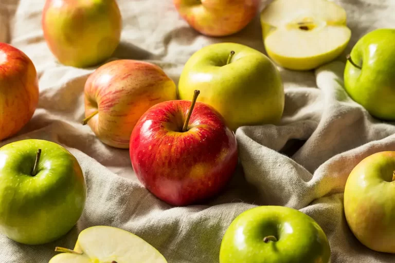 A variety of apples on a cloth backdrop.