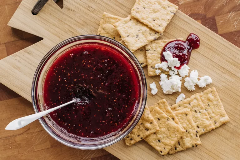 Fig jam on a cutting board with crackers and goat cheese.