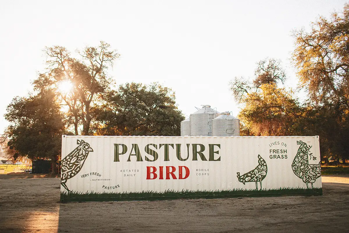 A sign for Pasturebird painted on a shipping container.