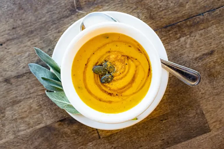 Butternut Squash soup in a bowl on a wood table.