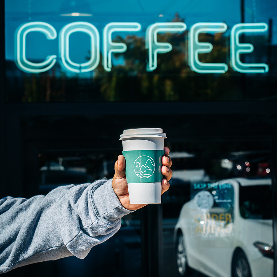 A person holding a cup of Pachamama Coffee.