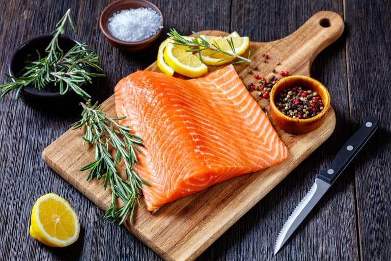 A raw salmon steak on a cutting board.