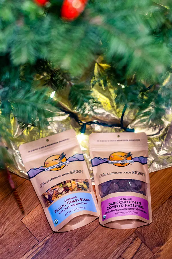 Bags of Hummingbird Snacks under a Christmas tree.