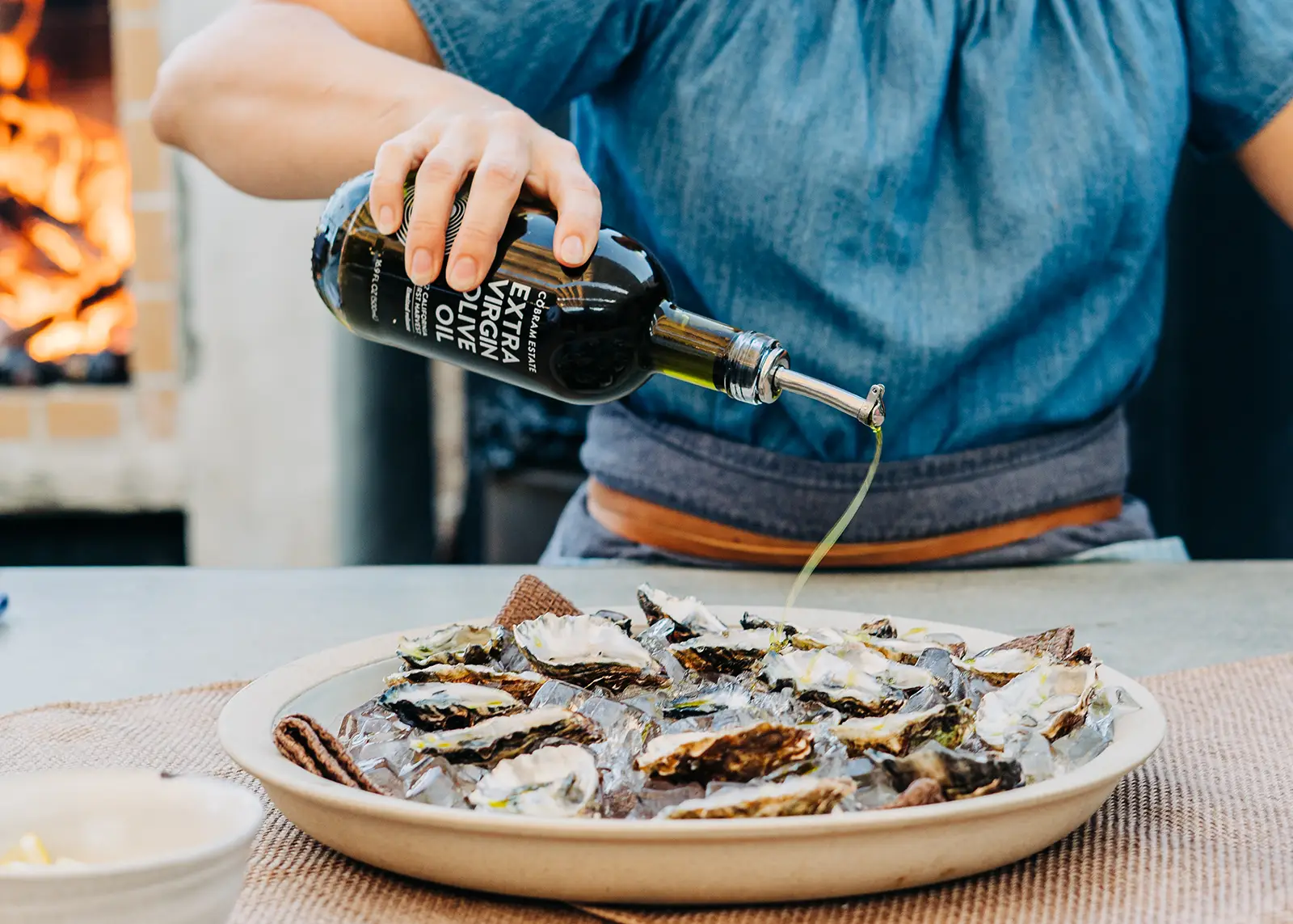 Olive oil being drizzled onto oysters.