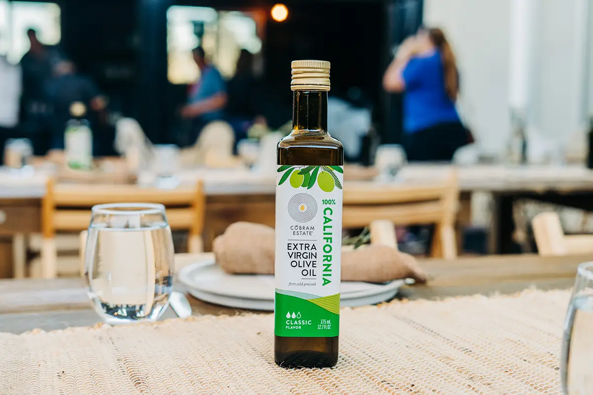 A bottle of Cobram Estate Olive Oil on a table.