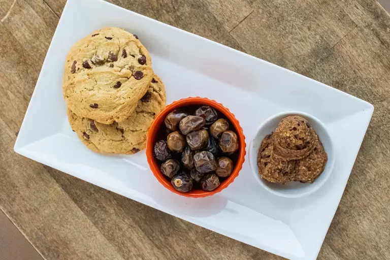 Date cookie dough on a tray with fresh dates and baked chocolate chip cookie dough.