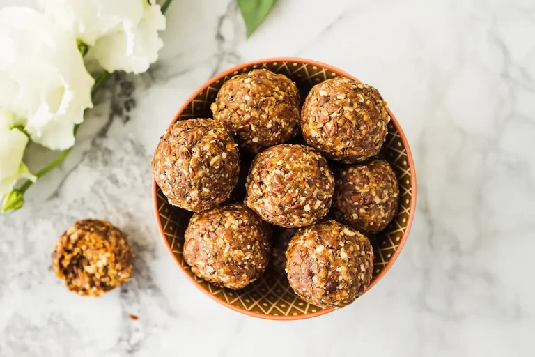 Energy protein balls with healthy ingredients on marble table.