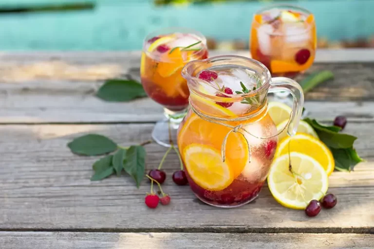 Sangria cocktails with fresh fruits, berries and rosemary.