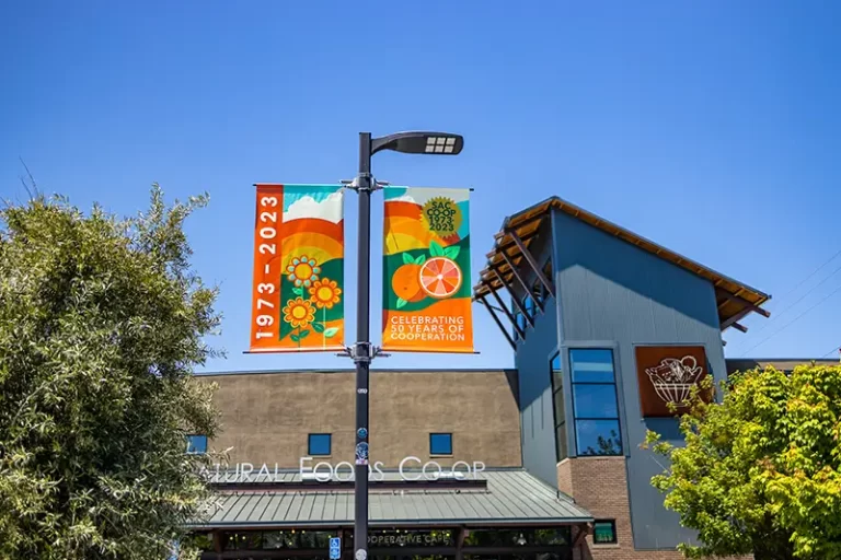 Exterior view of the Co-op with 50th Anniversary flags waving above the parking lot.