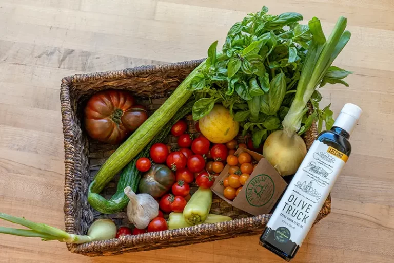 A collection of gapzacho ingredients, tomatoes, cucumbers and peppers in a basket.