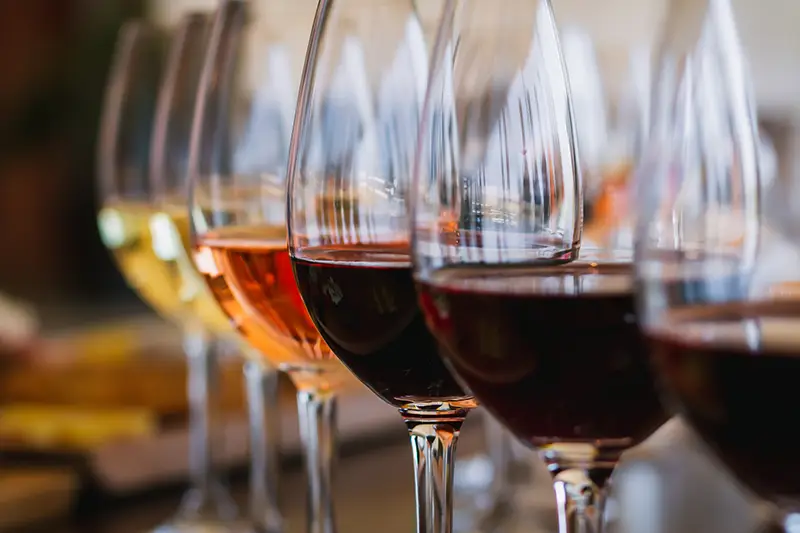 Selective focus on a selection of red, rose and white wines during a wine tasting event.