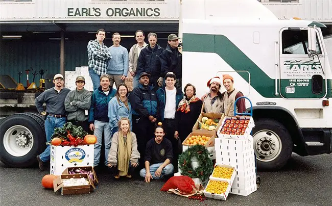A group of employees from Earl's Organic Produce in front of a produce truck.