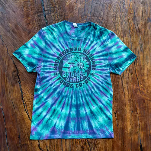 A blue and purple tie dye Co-op anniversary shirt.