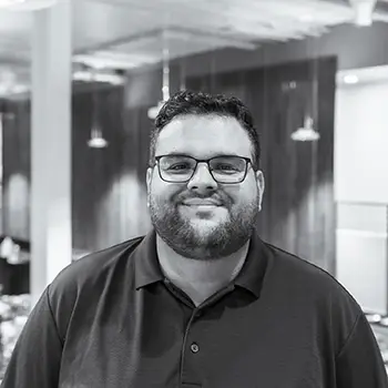 A black and white portrait of Board member, Brian Pimentel.