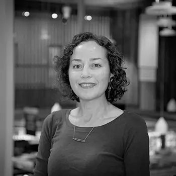 A black and white portrait of Board member, Delfina Vargas.