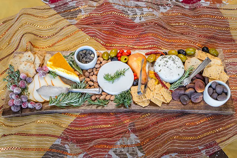A collection of plant-based meats and cheeses on a charcuterie board.