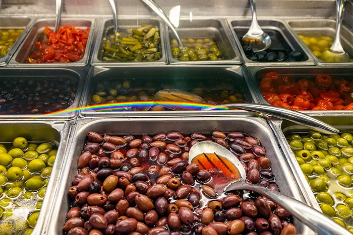 A close up of the olive bar with a colorful variety of olives.