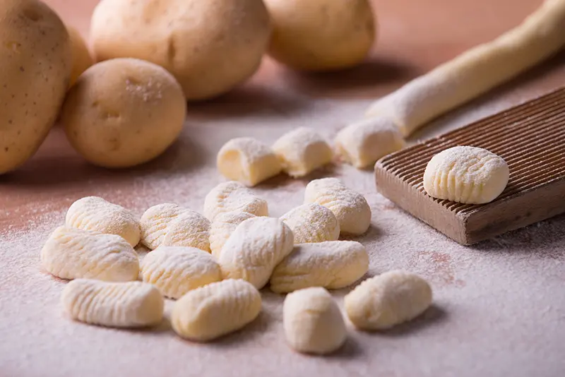 Homemade gnocchi on a wooden board.