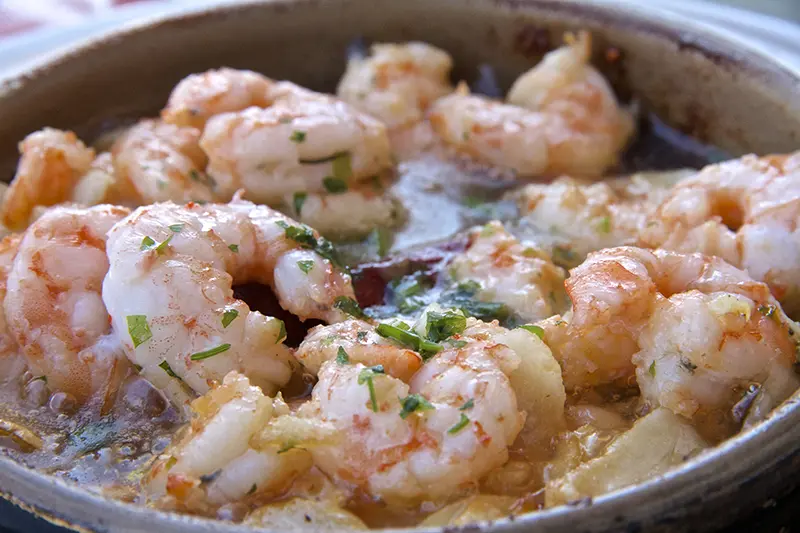 Shrimp with garlic being cooked in a skillet.